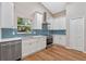 Bright kitchen featuring white cabinetry, stainless steel appliances, and a stylish blue backsplash at 4324 Leafway Cir, Leesburg, FL 34748