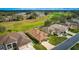 Aerial view of a single-story home nestled in a community with a lush golf course and mature trees at 4835 Kelso St, Leesburg, FL 34748