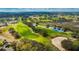 Aerial view of a lush golf course with a winding waterway and sand traps, surrounded by residences and natural landscape at 4835 Kelso St, Leesburg, FL 34748