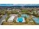 Aerial view of a community pool, tennis courts, and clubhouse with ample parking at 4835 Kelso St, Leesburg, FL 34748