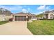 Charming single-story home featuring a well-maintained lawn, neutral stucco, and a two-car garage at 4835 Kelso St, Leesburg, FL 34748