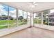 Sunroom with large windows showcasing the outdoors with natural light and a ceiling fan at 4835 Kelso St, Leesburg, FL 34748