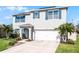 Two story home boasts a manicured lawn, blue shutters, solar panels, and a two car garage at 5363 Timberland Ave, St Cloud, FL 34771