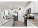 Bright kitchen featuring granite countertops, stainless steel appliances, tile backsplash, and an island sink at 5363 Timberland Ave, St Cloud, FL 34771