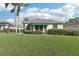 Back exterior view of house with awning-covered patio and lush lawn at 592 Juniper Way, Tavares, FL 32778