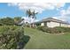 Back yard of a single story home with green grass and manicured bushes at 592 Juniper Way, Tavares, FL 32778