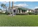 A lush green backyard featuring well-manicured landscaping and a patio awning at 592 Juniper Way, Tavares, FL 32778