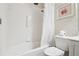 Bright bathroom with a white shower and bathtub combination and a toilet with a painting on the wall at 592 Juniper Way, Tavares, FL 32778