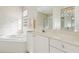 Relaxing bathroom featuring a soaking tub, bright lighting, and elegant decor elements for a spa-like experience at 592 Juniper Way, Tavares, FL 32778