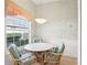 Charming breakfast nook with floral wallpaper, large window view, and wicker seating beneath a pendant light at 592 Juniper Way, Tavares, FL 32778