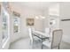 Dining room featuring a glass top table, chandelier, and a large window offering natural light and peaceful views at 592 Juniper Way, Tavares, FL 32778