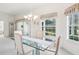 Light-filled dining area with a modern table, chandelier, and sliding glass doors leading to the outdoor space at 592 Juniper Way, Tavares, FL 32778