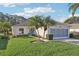 Charming home with green grass, palm trees and manicured shrubs at 592 Juniper Way, Tavares, FL 32778