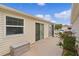 Backyard featuring a concrete patio with sliding glass doors and manicured landscaping at 620 Vagabond St, The Villages, FL 32163