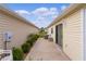 Exterior view of a backyard featuring a concrete patio, landscaping, and a home's facade at 620 Vagabond St, The Villages, FL 32163