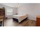 Cozy bedroom with wood-look floors, a ceiling fan, and a patterned quilt at 620 Vagabond St, The Villages, FL 32163