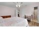 Bright bedroom boasts an ensuite bathroom, wood-look floors, and ceiling fan at 620 Vagabond St, The Villages, FL 32163