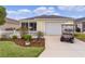 Inviting home with a manicured lawn, charming white picket fence, and golf cart at 620 Vagabond St, The Villages, FL 32163