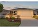 Well-kept home with a manicured lawn and charming white picket fence as the sun sets at 620 Vagabond St, The Villages, FL 32163