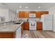 Well-equipped kitchen featuring wood cabinets, a white appliance package, and ample counter space at 620 Vagabond St, The Villages, FL 32163