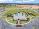 Aerial view of a community pool with parking, playground, and recreation fields at 7193 Dilly Lake Ave, Groveland, FL 34736