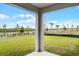 A covered back patio shows the community landscape with plants and palm trees at 7193 Dilly Lake Ave, Groveland, FL 34736