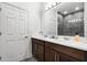 Elegant bathroom featuring double sinks with a stylish vanity, and a glass-enclosed shower at 7193 Dilly Lake Ave, Groveland, FL 34736