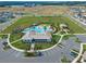 Aerial view of a community pool featuring recreation fields, parking, and a playground at 7193 Dilly Lake Ave, Groveland, FL 34736