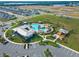 Aerial view of the community pool and clubhouse with parking and manicured landscaping at 7193 Dilly Lake Ave, Groveland, FL 34736