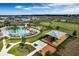 Aerial view of a beautiful community pool with lounge chairs, playground and lush green space at 7193 Dilly Lake Ave, Groveland, FL 34736