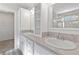Bathroom featuring dual sinks, generous counter space, and linen storage at 7315 Cornwall Way, The Villages, FL 34762