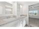 En-suite bathroom featuring dual sinks, white cabinetry, framed mirror, and a separate standing shower at 7315 Cornwall Way, The Villages, FL 34762