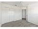 Bedroom with neutral carpet, white walls, ceiling fan, closet, and doorway at 7315 Cornwall Way, The Villages, FL 34762
