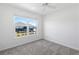 Bedroom features neutral carpet, white walls, ceiling fan and a window at 7315 Cornwall Way, The Villages, FL 34762