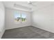 Bedroom featuring neutral carpet, white walls, a ceiling fan, and a window at 7315 Cornwall Way, The Villages, FL 34762
