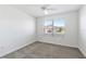 Bedroom with neutral carpet, white walls, a ceiling fan, and a window at 7315 Cornwall Way, The Villages, FL 34762