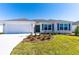 Charming single-story home featuring a two-car garage, manicured lawn and colorful window shutters at 7315 Cornwall Way, The Villages, FL 34762