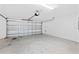 Well-lit garage with automatic door and finished concrete flooring at 7315 Cornwall Way, The Villages, FL 34762