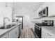 Kitchen with white cabinets, stainless steel appliances, and kitchen island with double sink at 7315 Cornwall Way, The Villages, FL 34762