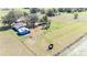 Aerial view of a barn with a metal roof, surrounded by fenced pastures, presenting a rural and functional property at 8230 Se 23Rd Dr, Webster, FL 33597