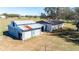 Exterior view of a barn featuring metal siding and roll-up doors, situated on a grassy lot at 8230 Se 23Rd Dr, Webster, FL 33597