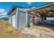 Exterior view of barn structure with covered section and corrugated metal siding on a sunny day at 8230 Se 23Rd Dr, Webster, FL 33597