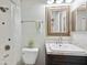 Bright bathroom with a shower, decorative mirror, and a vanity with marble-style countertops at 8230 Se 23Rd Dr, Webster, FL 33597