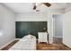 Bedroom features a decorative green accent wall, wood-look floors, and lots of natural light at 8230 Se 23Rd Dr, Webster, FL 33597