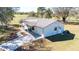 Exterior aerial shot showing the home's metal roof and driveway, surrounded by a manicured lawn at 8230 Se 23Rd Dr, Webster, FL 33597