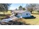 Aerial view of the home featuring a driveway, metal roof, and well-manicured lawn, offering an inviting curb appeal at 8230 Se 23Rd Dr, Webster, FL 33597