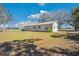 Rear exterior view of home with sliding glass doors, lush lawn and tall communication tower at 8230 Se 23Rd Dr, Webster, FL 33597