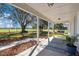 Inviting front porch with a swing, patterned rug, and views of the expansive, fenced yard at 8230 Se 23Rd Dr, Webster, FL 33597