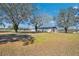 Wide exterior shot of a barn and driveway surrounded by lawn and majestic oak trees at 8230 Se 23Rd Dr, Webster, FL 33597