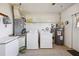 Functional laundry room with a washer, dryer, water heater, and shelving for storage at 8230 Se 23Rd Dr, Webster, FL 33597